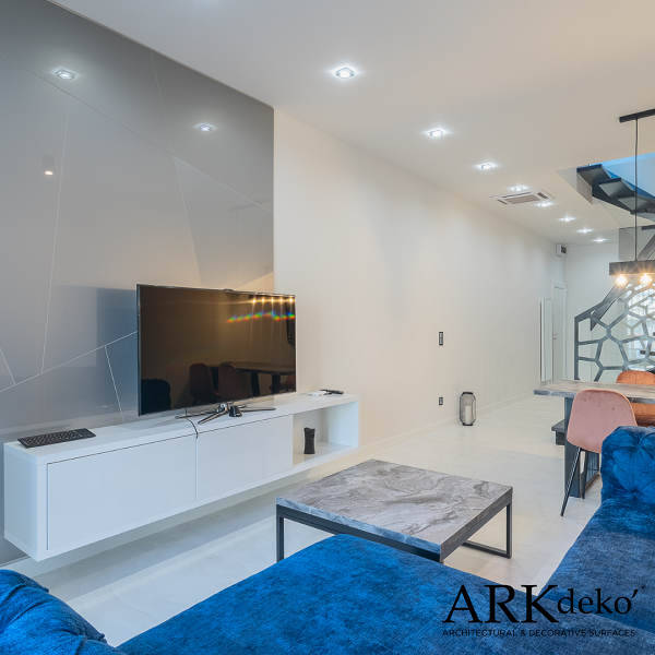 Pavimento in resina autolivellante bianco, divano blu petrolio, appartamento moderno con cucina laccata